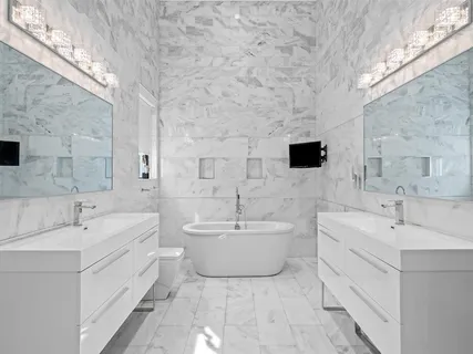 a bathroom with a double vanity sink a mirror and a bathtub