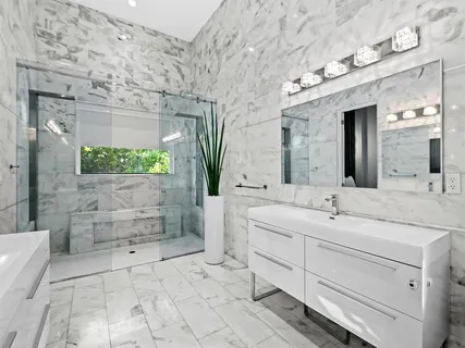 a spacious bathroom with a granite countertop sink a mirror and a shower