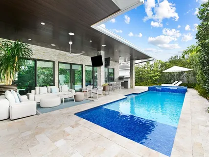 a living room with patio furniture and a large tree
