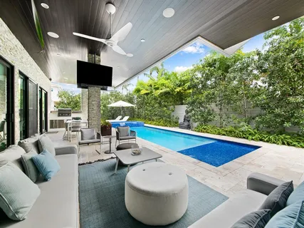a view of a patio with couches table and chairs with potted plants
