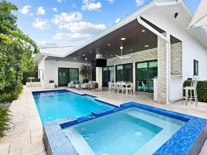 a view of a house with swimming pool and sitting area