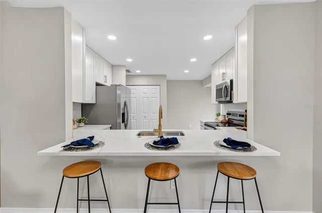 a kitchen with stainless steel appliances granite countertop a stove and white cabinets