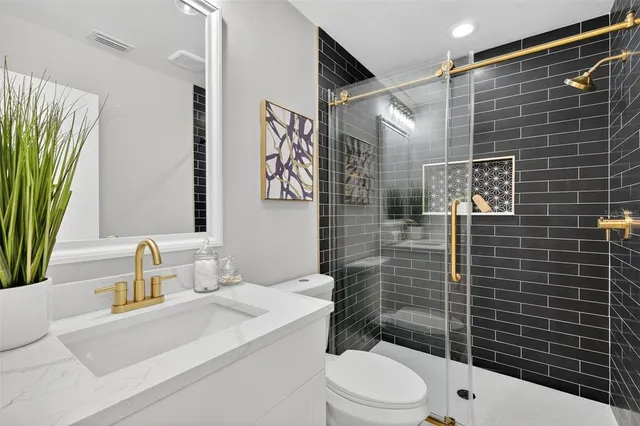 a bathroom with a sink a toilet and shower