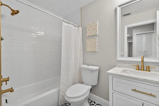 a bathroom with a toilet sink vanity tub and shower