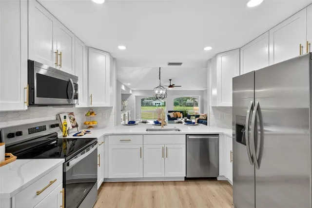 a kitchen with a sink stainless steel appliances and white cabinets