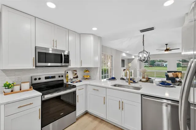 a kitchen with appliances a sink and cabinets