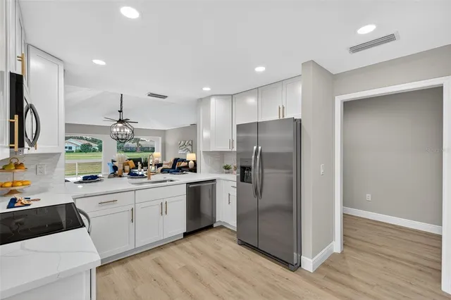 a kitchen with stainless steel appliances a refrigerator sink and microwave