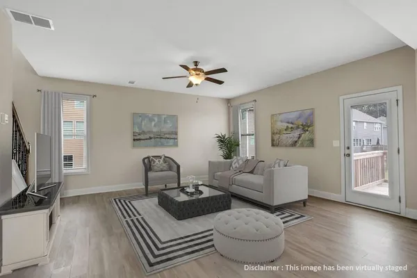 a living room with furniture a flat screen tv and a window