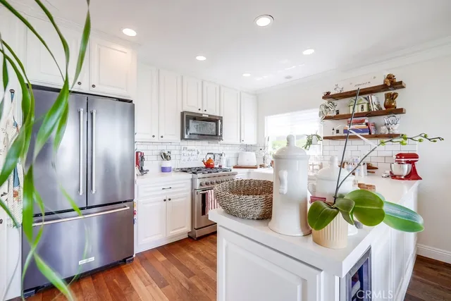 a kitchen with stainless steel appliances a sink stove top oven and cabinets