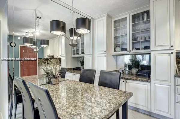 a kitchen with stainless steel appliances kitchen island granite countertop a table and chairs