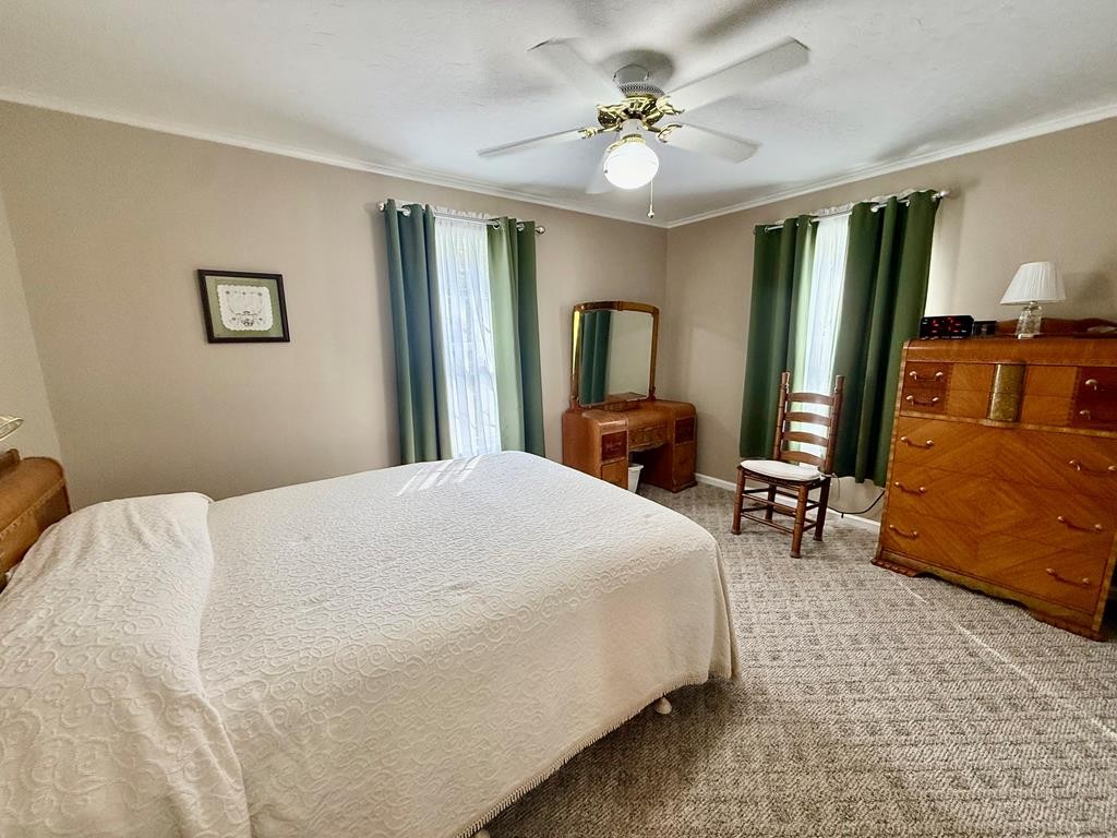 180 Center Drive Springville, TN 38256 - Photo 12 of 30 a spacious bedroom with a bed a couch and a chandelier