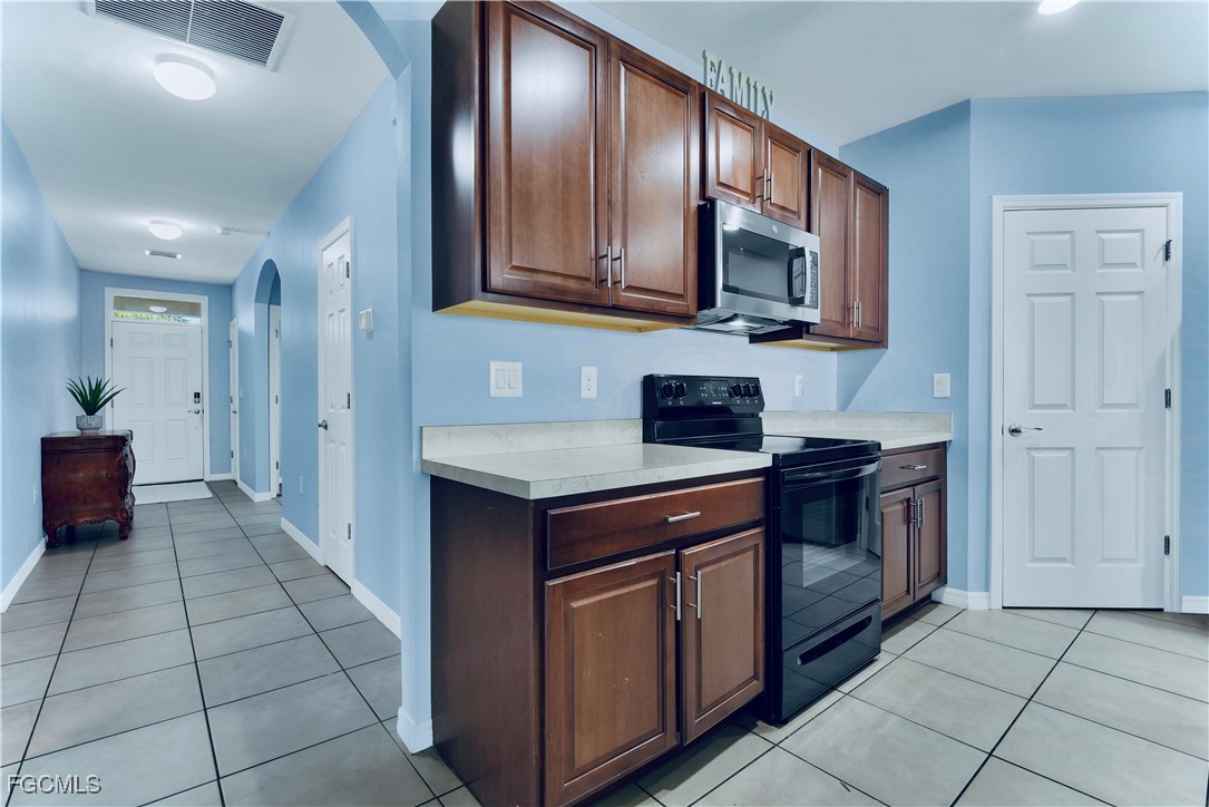 10357 Silver Pond Lane Lehigh Acres, FL 33936 - Photo 9 of 25 a kitchen with stainless steel appliances granite countertop a refrigerator and a stove top oven