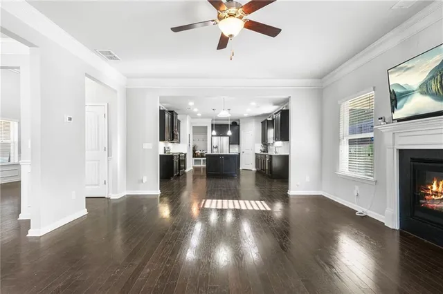 a view of a living room with wooden floor and a fireplace