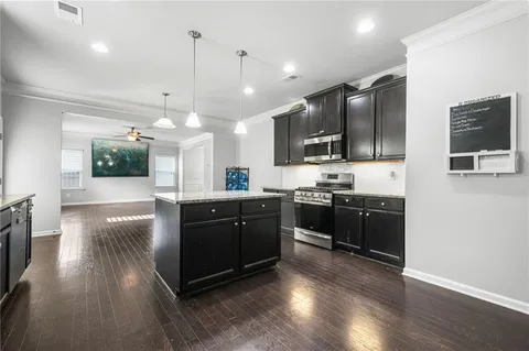 a large kitchen with stainless steel appliances and wooden floors