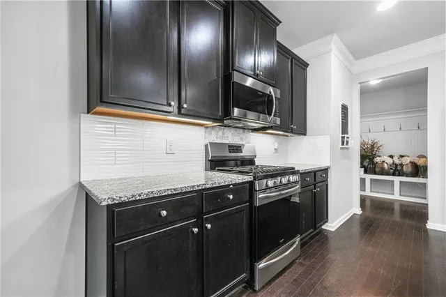 a kitchen with stainless steel appliances granite countertop a stove and a microwave