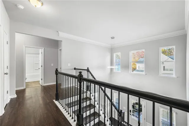 a view of a hallway with wooden floor and stairs