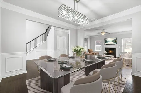 a dining room with furniture a chandelier and wooden floor