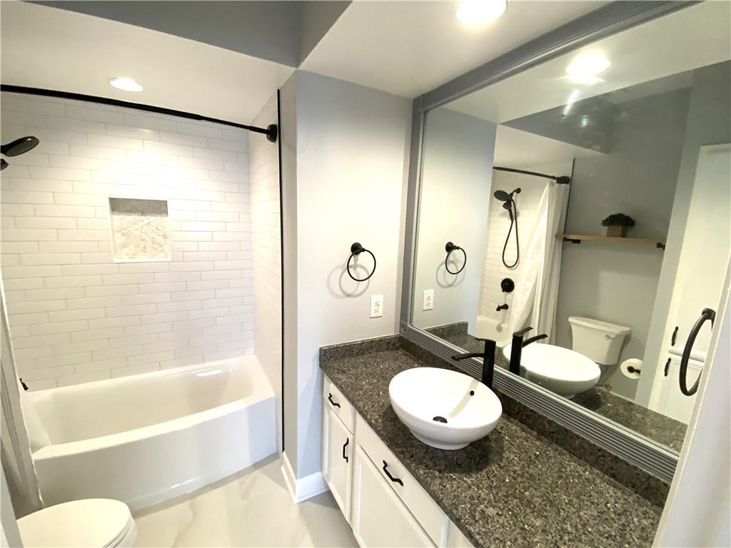 3777 Peachtree Road Northeast, Unit 1517 Atlanta, GA 30319 - Photo 25 of 37 a bathroom with a granite countertop sink mirror toilet and bathtub