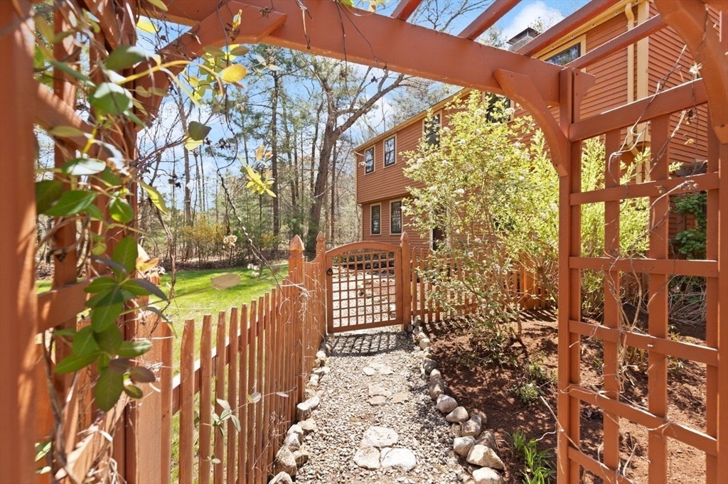 2 Briggs Pond Way Sharon, MA 02067 - Photo 40 of 42 a view of a brick house with a small yard and wooden fence