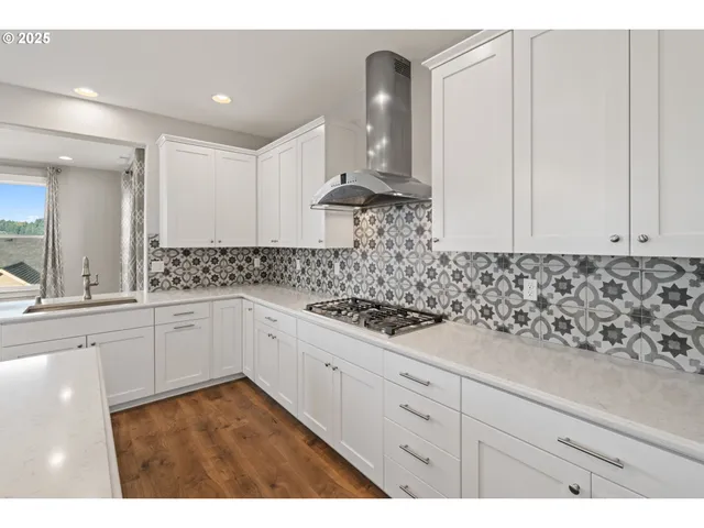 a kitchen with white cabinets and appliances