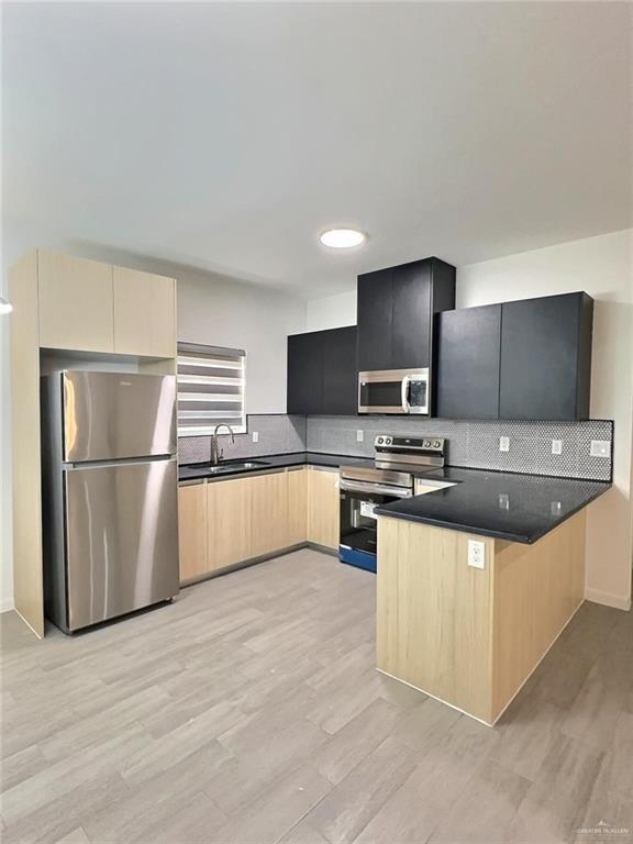 3912 Ventura Avenue, Unit 2 Edinburg, TX 78541 - Photo 2 of 12 a kitchen with stainless steel appliances granite countertop a refrigerator a stove a sink and a microwave