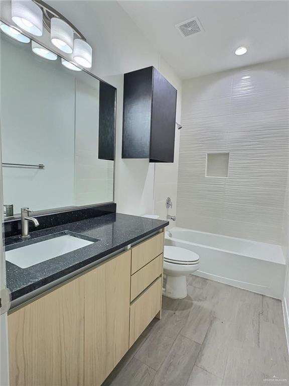3912 Ventura Avenue, Unit 2 Edinburg, TX 78541 - Photo 7 of 12 a bathroom with a granite countertop sink a toilet a mirror and bathtub
