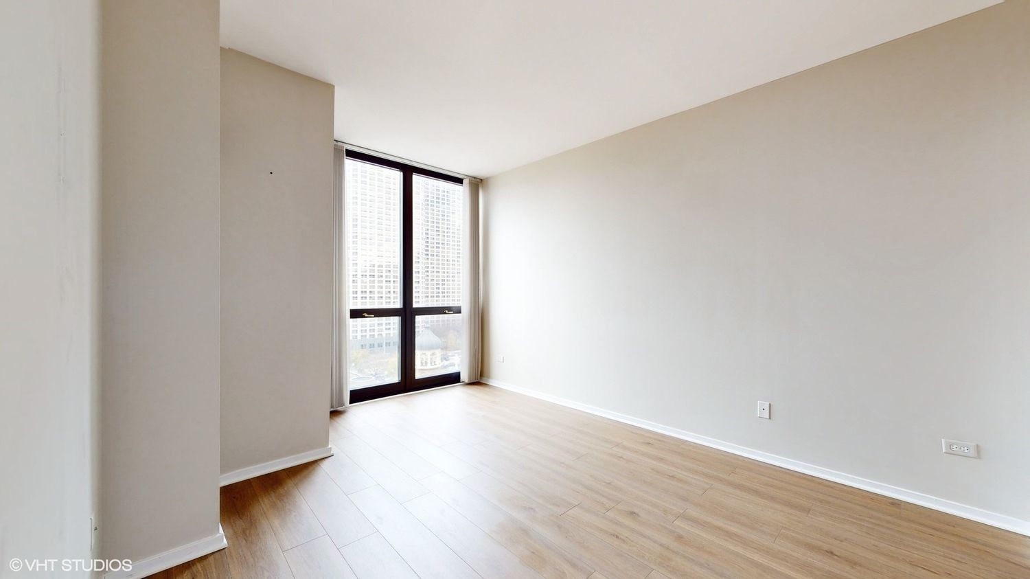 210 South Desplaines Street, Unit 907 Chicago, IL 60661 - Photo 11 of 17 a view of an empty room with wooden floor and a window