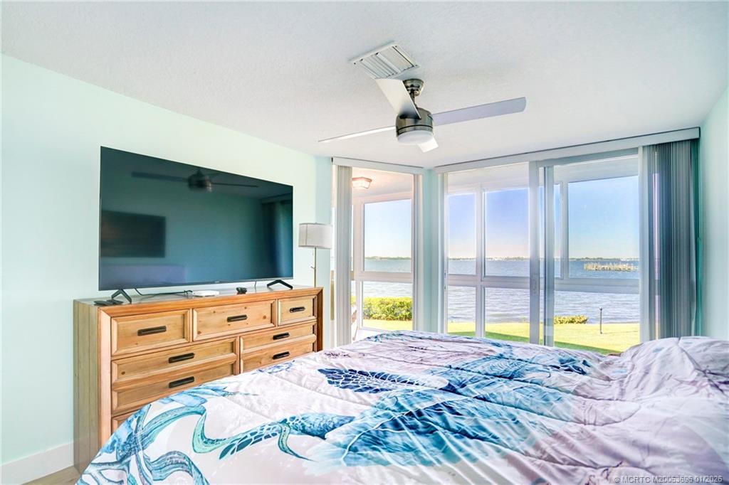 2370 Northeast Ocean Boulevard, Unit C205 Stuart, FL 34996 - Photo 56 of 80 a bedroom with a bed and a flat tv screen on dresser