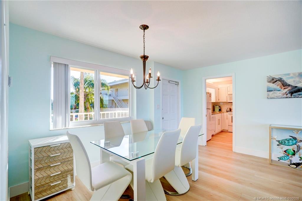 2370 Northeast Ocean Boulevard, Unit C205 Stuart, FL 34996 - Photo 9 of 80 a dining room with furniture a chandelier and wooden floor