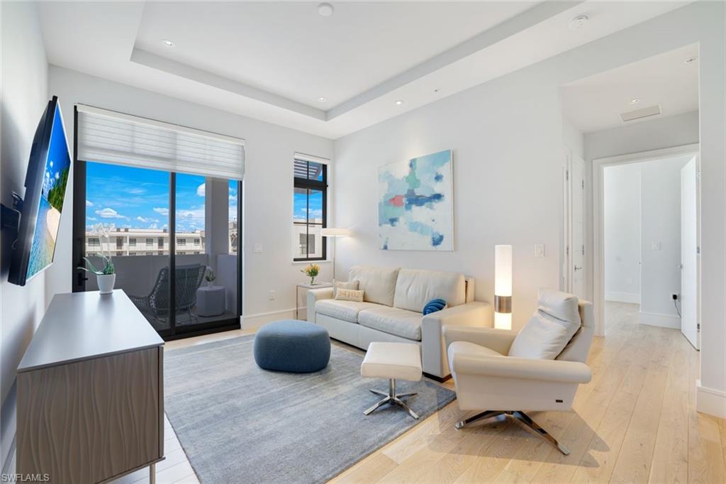 101 8th Street South, Unit 301 Naples, FL 34102 - Photo 3 of 17 a living room with furniture and a floor to ceiling window