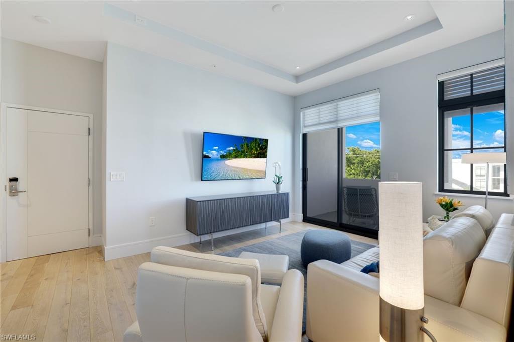 101 8th Street South, Unit 301 Naples, FL 34102 - Photo 4 of 17 a living room with furniture and a flat screen tv