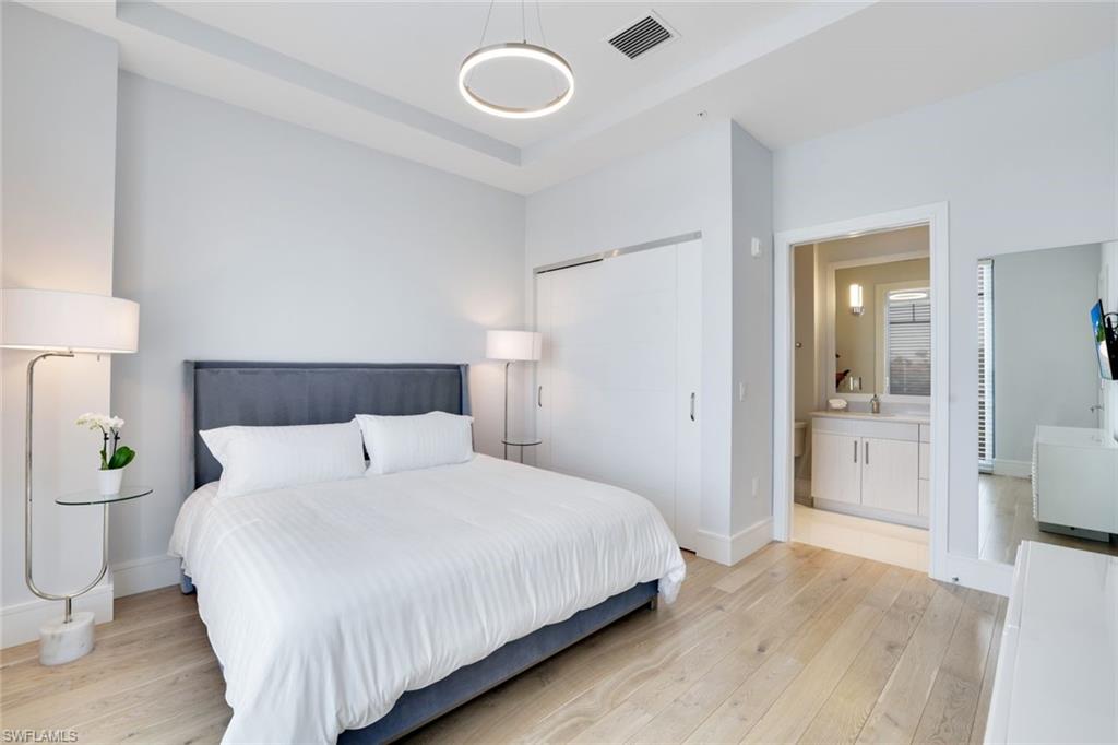 101 8th Street South, Unit 301 Naples, FL 34102 - Photo 9 of 17 a bedroom with a bed and a lamp