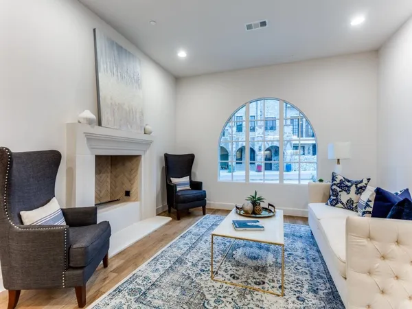 a living room with furniture a fireplace and a chandelier