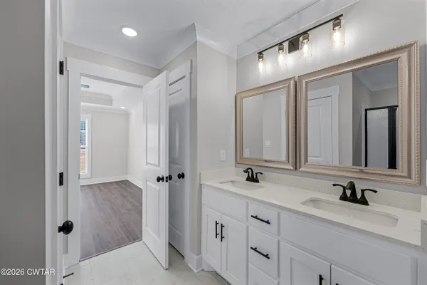 a bathroom with double vanity sinks a mirror and a shower
