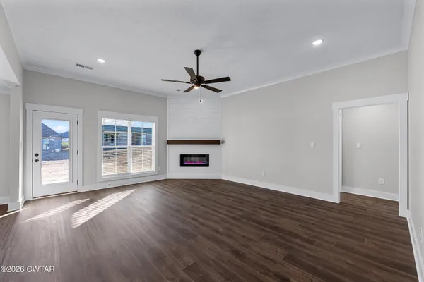a view of a hallway with wooden floor and a bathroom