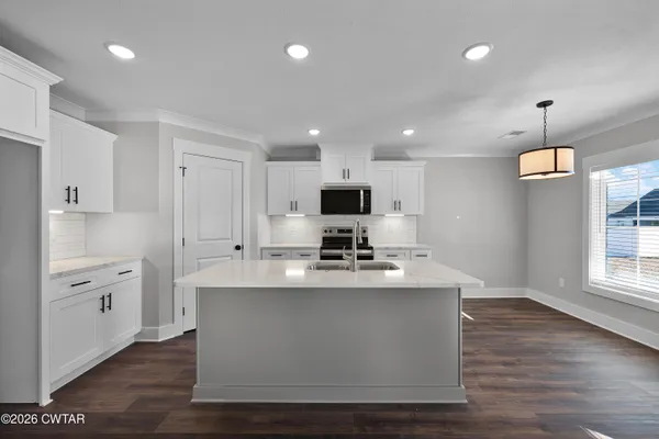 a view of a kitchen with a sink refrigerator and wooden floor