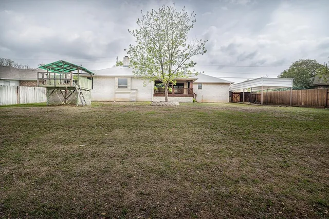 a big yard with table and chairs in front of house