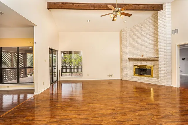 a view of a room with wooden floor and a window
