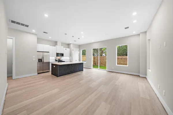 a view of a kitchen with a sink and dishwasher a oven with wooden floor