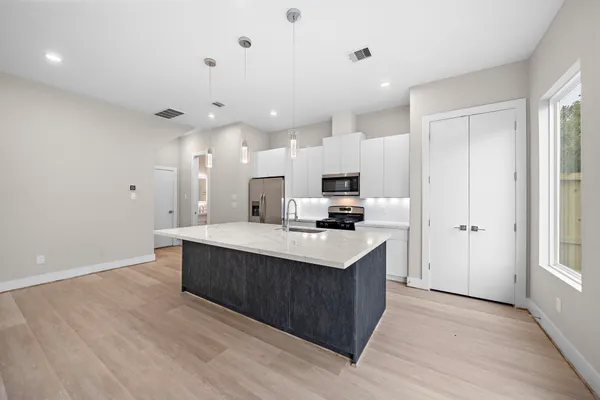 a kitchen with kitchen island sink stove and refrigerator