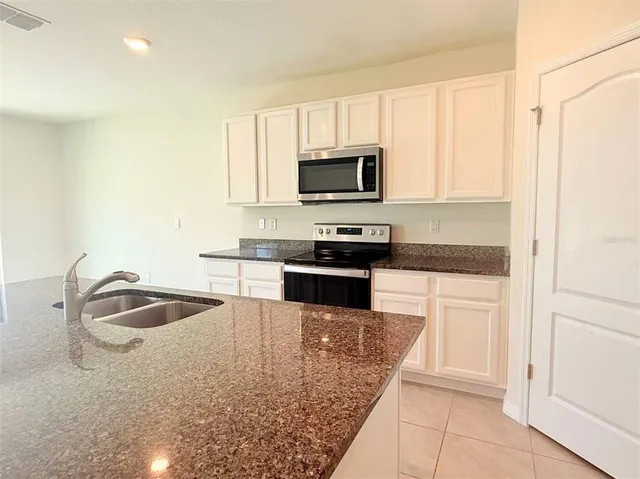 a kitchen with microwave stove and cabinets