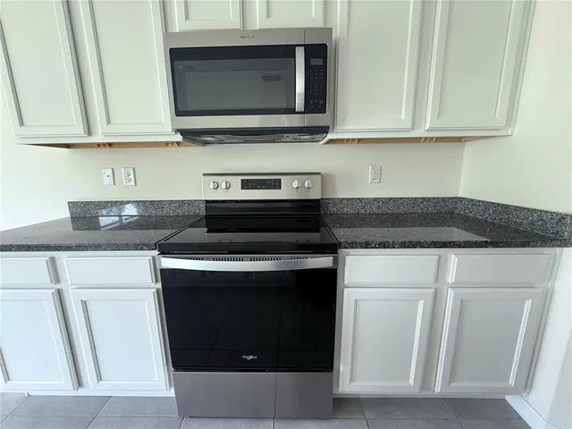 a kitchen with stainless steel appliances granite countertop a refrigerator and a stove