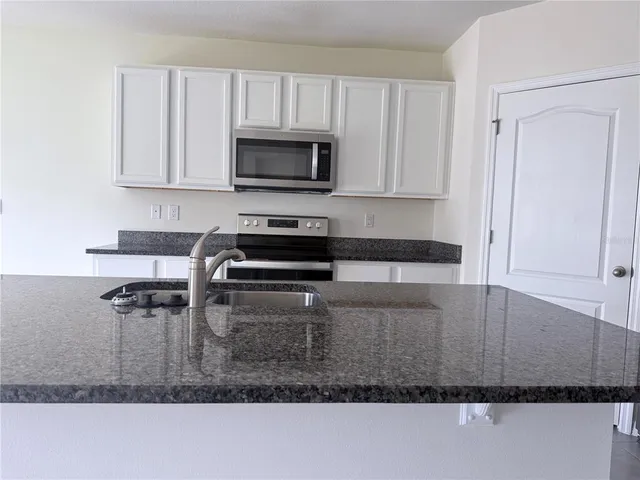 a kitchen with stainless steel appliances a refrigerator sink and stove