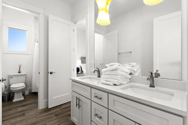 a spacious bedroom with a bed and a flat tv screen on dresser