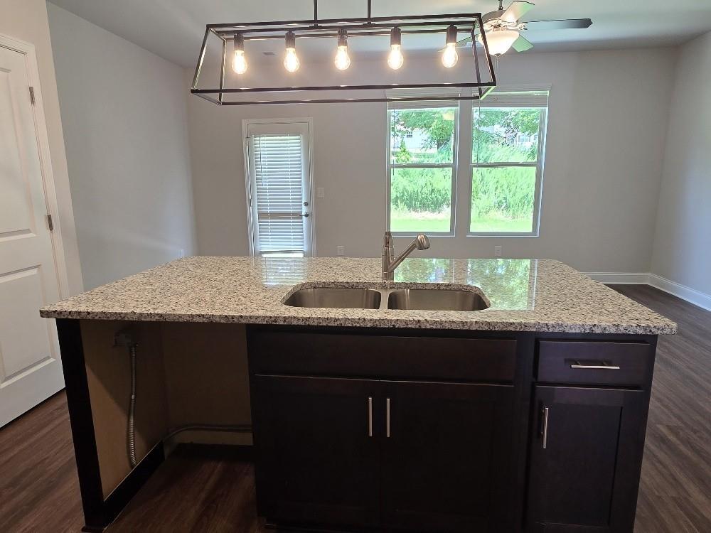 6198 Ripple Way, Unit 87 Atlanta, GA 30349 - Photo 5 of 23 a kitchen with a granite countertop sink window and wooden floor