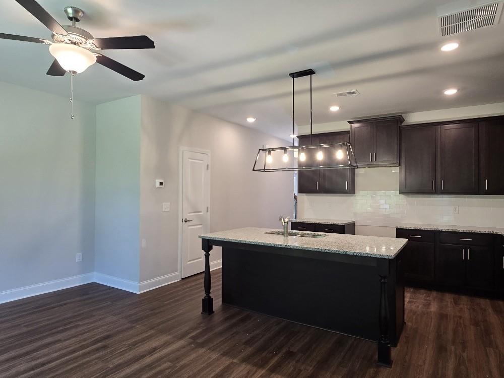 6198 Ripple Way, Unit 87 Atlanta, GA 30349 - Photo 8 of 23 a kitchen with a center island wooden floor and a view of living room