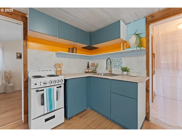 a kitchen with stainless steel appliances cabinets and a wooden floor