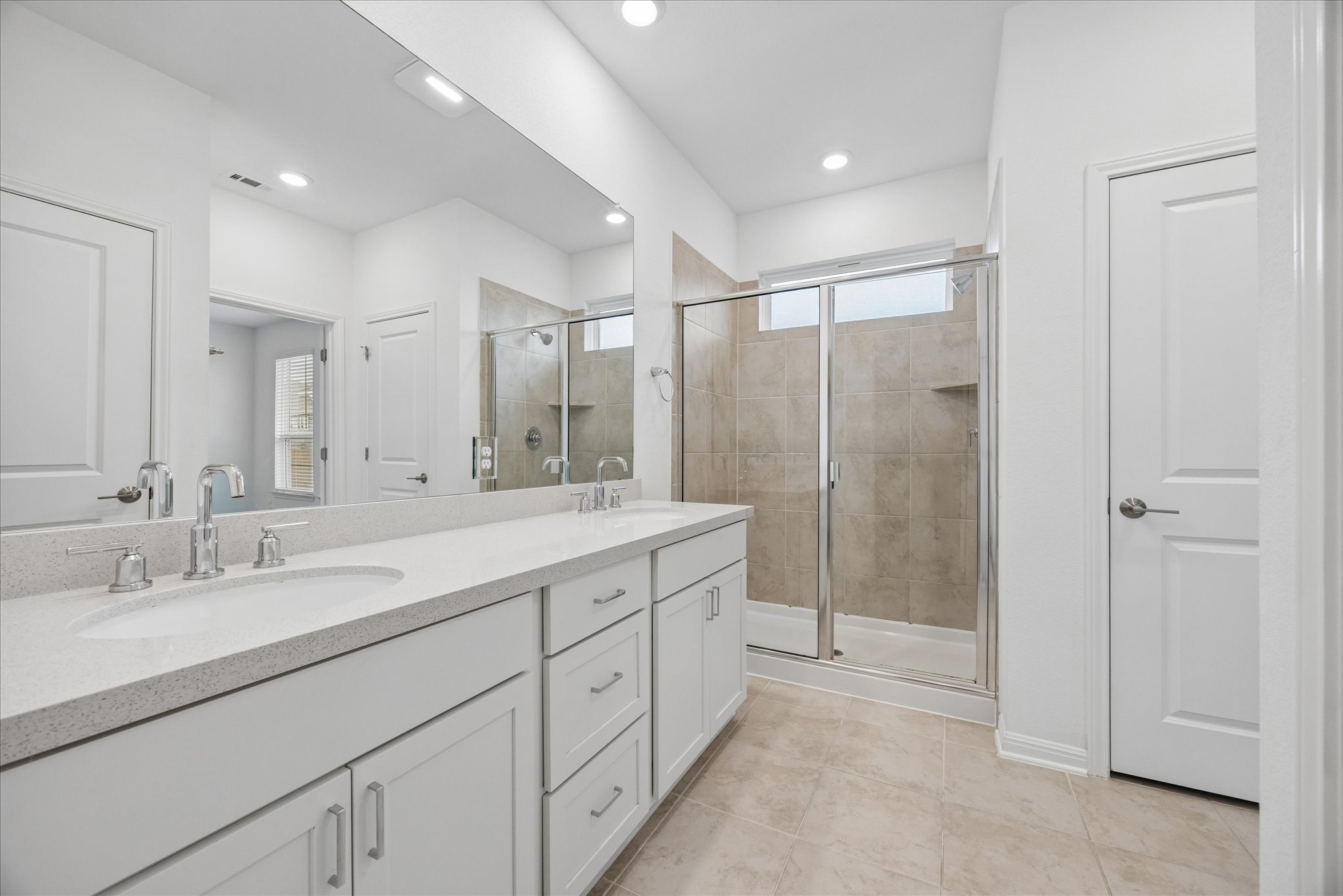 6407 Rounded Pebble Lane Buda, TX 78610 - Photo 15 of 32 A well-appointed bath features a dual vanity and a spacious walk-in shower.