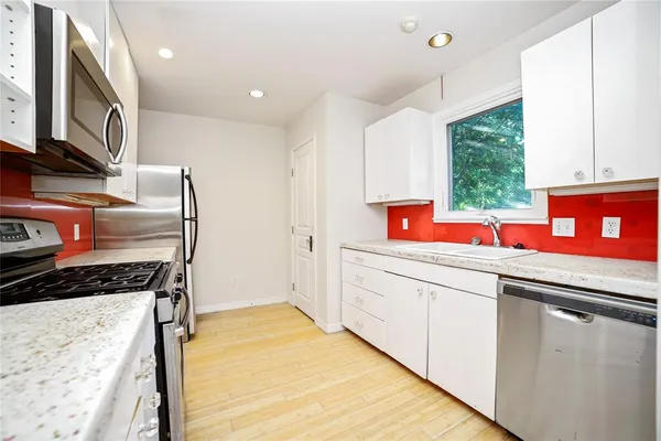 a kitchen that has a lot of cabinets in it and wooden floors