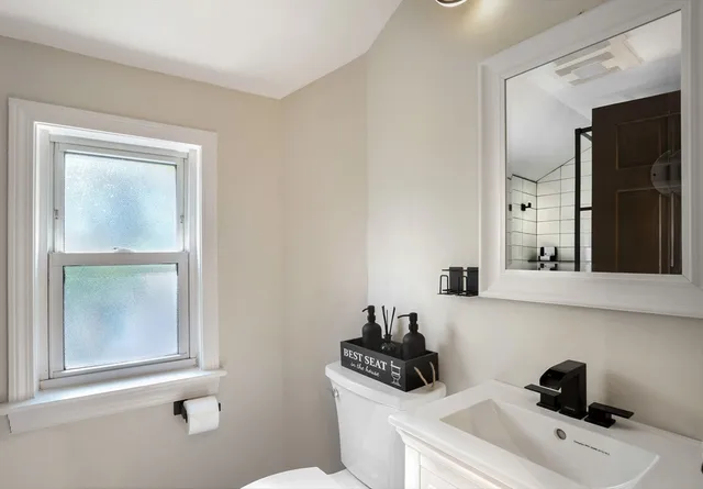 a bathroom with a sink a window and a mirror